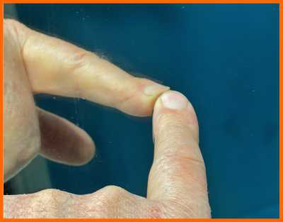 Finger test shows two-way mirror has coating on front of glass